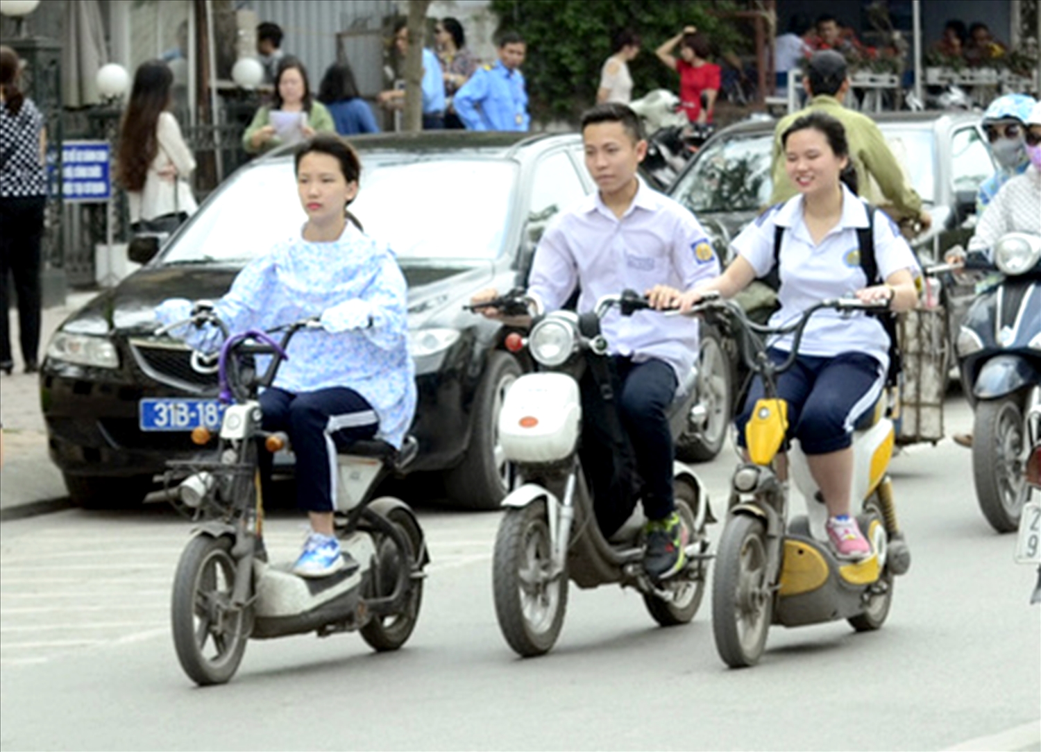 Nhiều học sinh điều khiển xe đạp điện không đội mũ bảo hiểm - ảnh MH