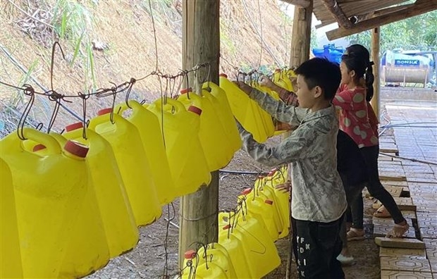 Học sinh Trường phổ thông dân tộc bán trú tiểu học Tả Gia Khâu, huyện Mường Khương dùng can nhựa lấy nước sử dụng sinh hoạt hàng ngày. (Ảnh: Quốc Khánh/TTXVN)