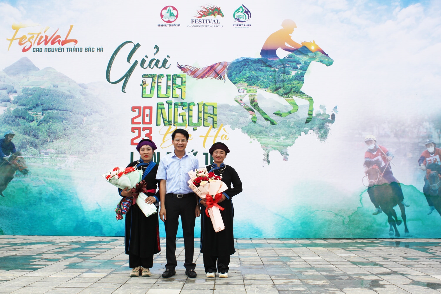 Ông Hoàng Văn Khoa - Phó Chủ tịch UBND huyện Bắc Hà trao tặng hoa, quà cho 2 nài ngựa nữ tham gia tích cực giải đua ngựa Bắc Hà qua các năm
