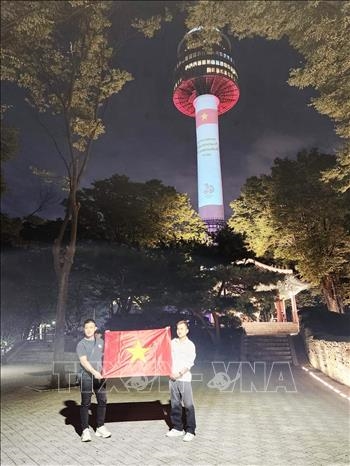 Quốc kỳ Việt Nam được trình chiếu trên đỉnh tháp Namsan và Tòa Thị chính ở trung tâm thủ đô Seoul tối 2/9/2023 - Ảnh: TTXVN