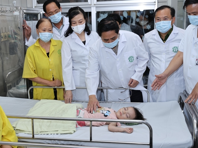 Thủ tướng thăm một cháu bé đang được cấp cứu tại Khoa Nhi - Ảnh: VGP/Nhật Bắc