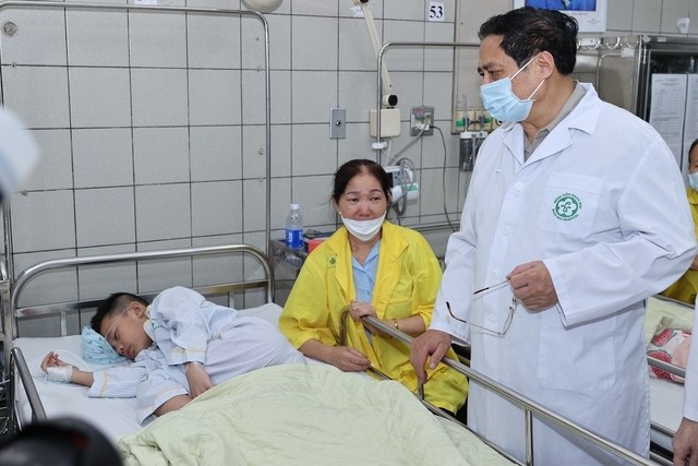 Thủ tướng thăm hỏi nạn nhân vụ cháy đang được điều trị, động viên thân nhân họ - Ảnh: VGP/Nhật Bắc