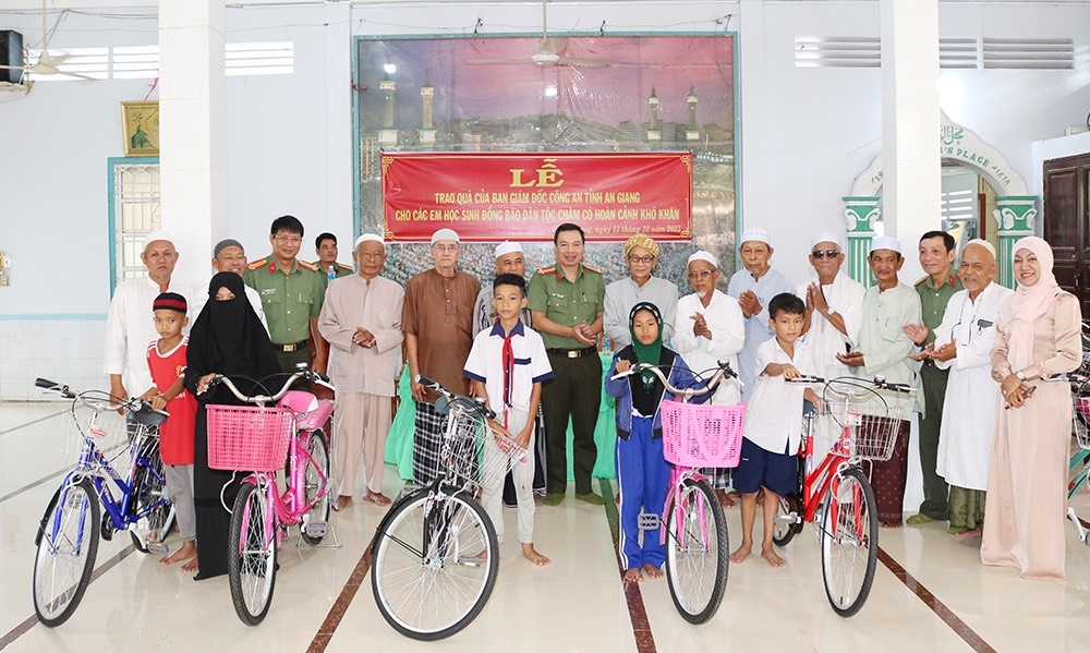 Đại tá Nguyễn Thanh Hà, Phó Giám đốc Công an tỉnh và Ông JacKy, Trưởng Ban đại diện Cộng đồng Hồi giáo tỉnh An Giang trao xe cho các em học sinh