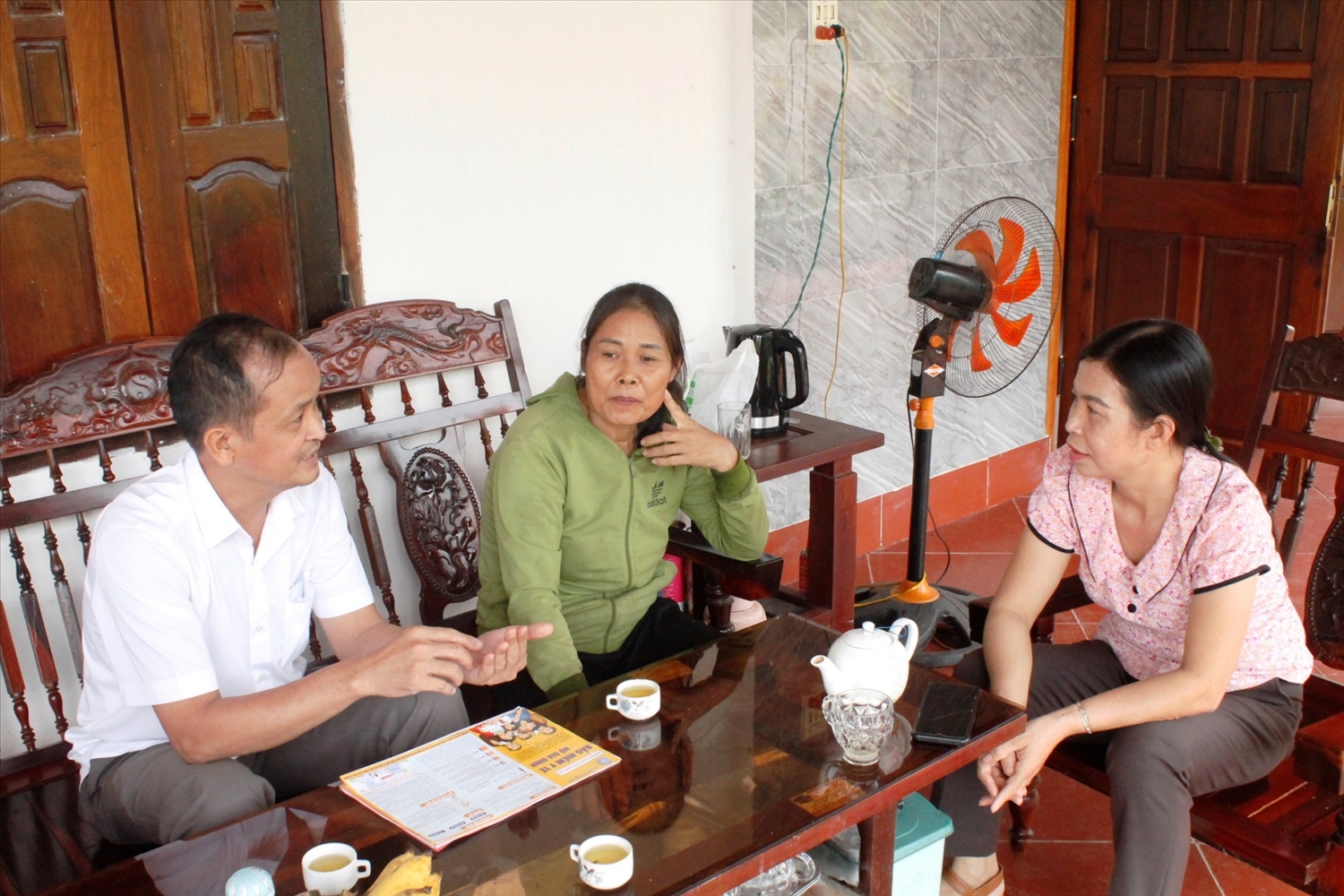 Bà Nguyễn Thị Hữu (bìa phải) tuyên truyền chính sách BHXH tự nguyện đến người dân.