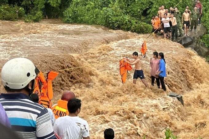 Lực lượng cứu hộ nhanh chóng giải cứu các cháu bé bị mắc kẹt giữa dòng nước lũ chảy xiết