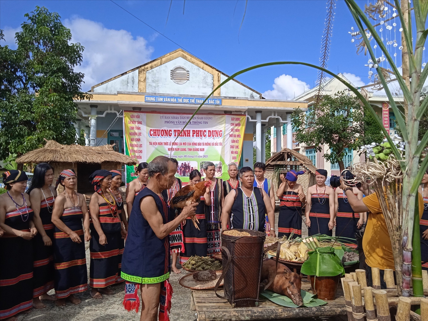 Già làng Nhiếr (cầm con gà trống) cùng người dân trong thông Đắc Tà Vâng tái hiện nghi thức lễ mừng lúa mới.