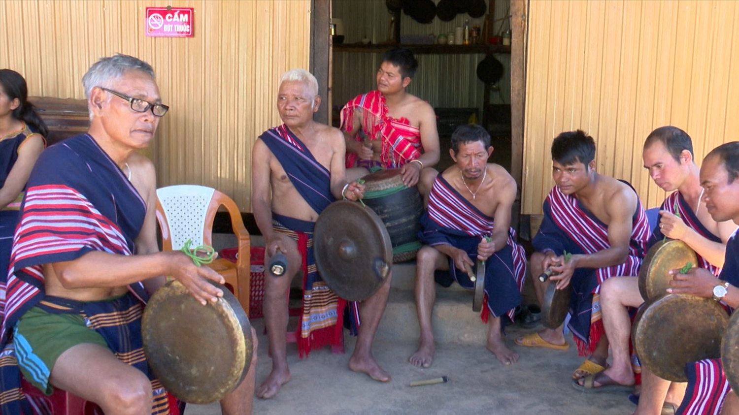 Nghệ nhân A Phênh (bên trái) truyền dạy cồng chiêng cho thanh niên trong thôn