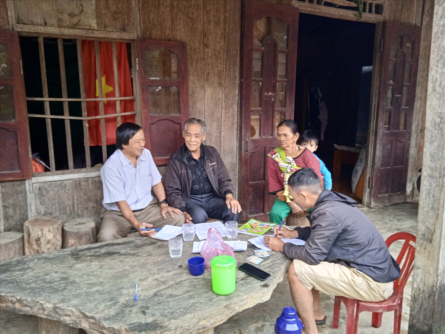Già làng - Người có uy tín A Nghí (người ngồi thứ 2 bên trái) trao đổi cùng tác giả về những khó khăn của thôn Lao Mưng.