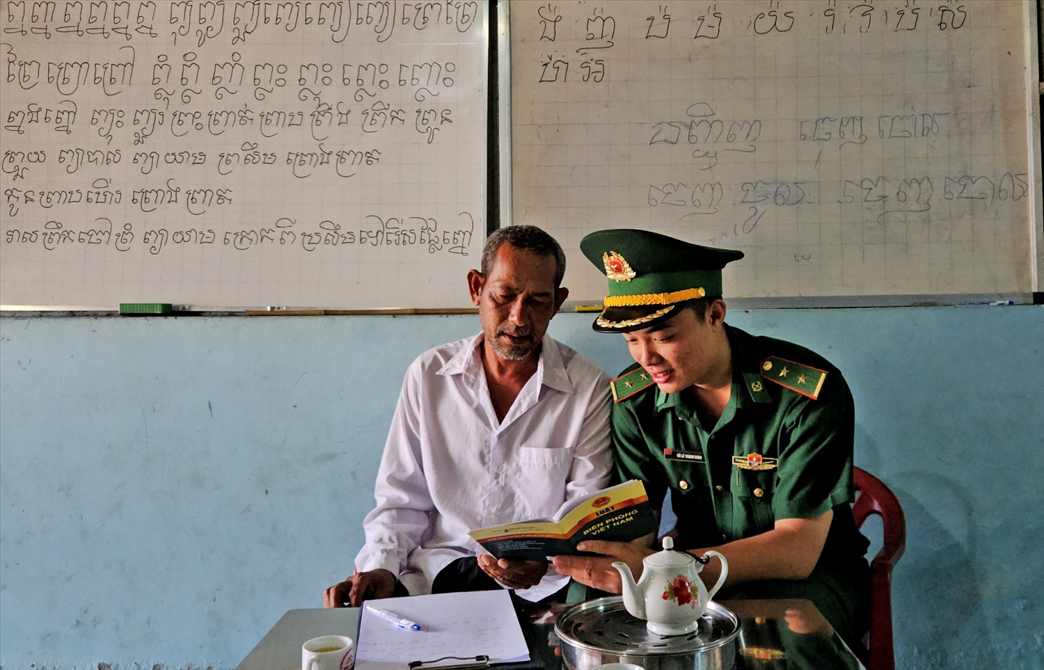 Ông Chau Che trao đổi cùng cán bộ Đồn Biên phòng Cửa khẩu quốc tế Tịnh Biên tuyên truyền cho đồng bào Khmer về các văn bản Luật Biên giới quốc gia. (Ảnh: Thành Hưng)