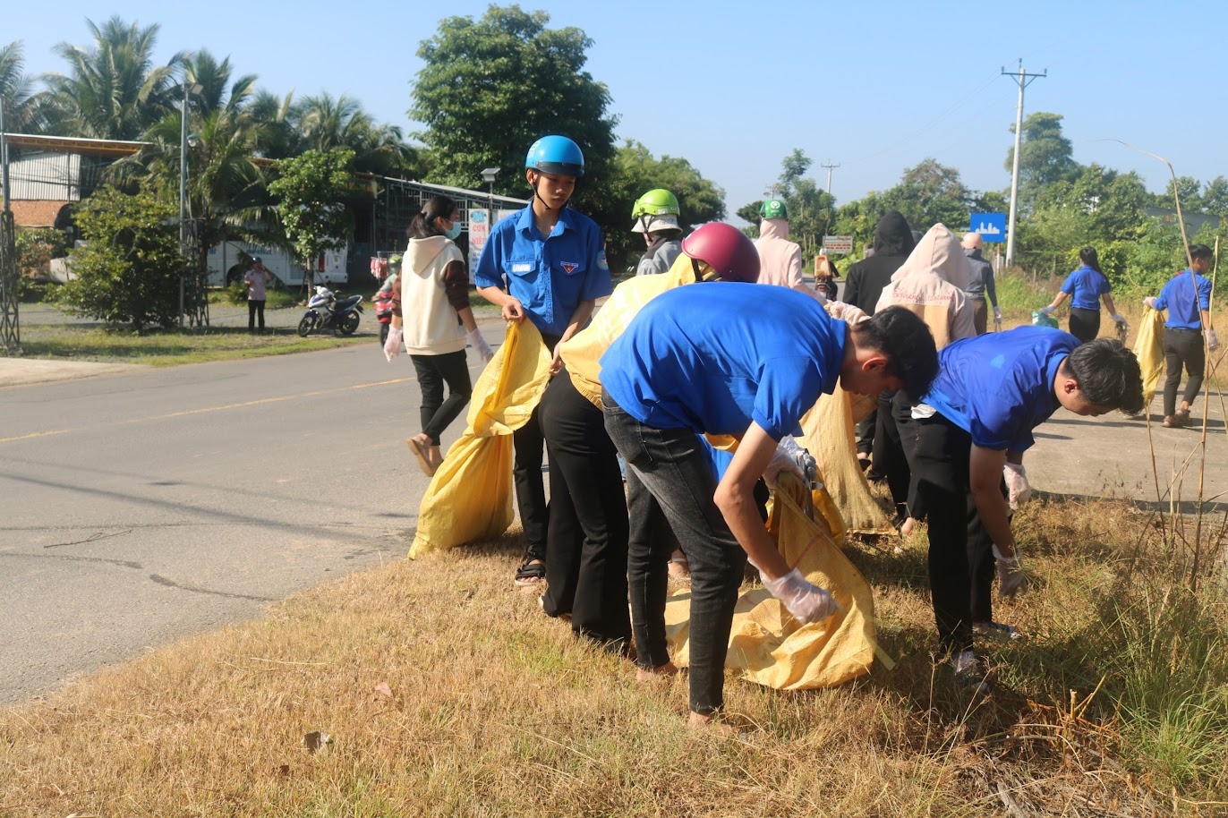Đoàn viên thanh niên huyện Đức Linh dọn dẹp rác thải ven đường ĐT.766 (Ảnh Thái Khoa)