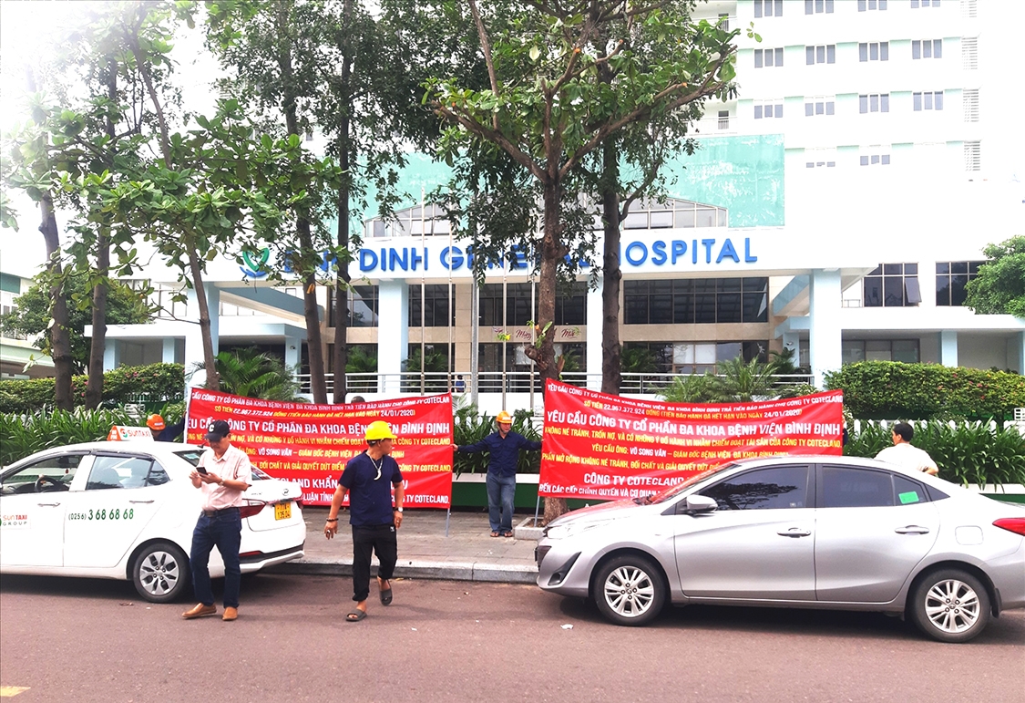 Nhóm người căng 2 băng rôn trước Công ty Cổ phần Bệnh viện đa khoa Bình Định