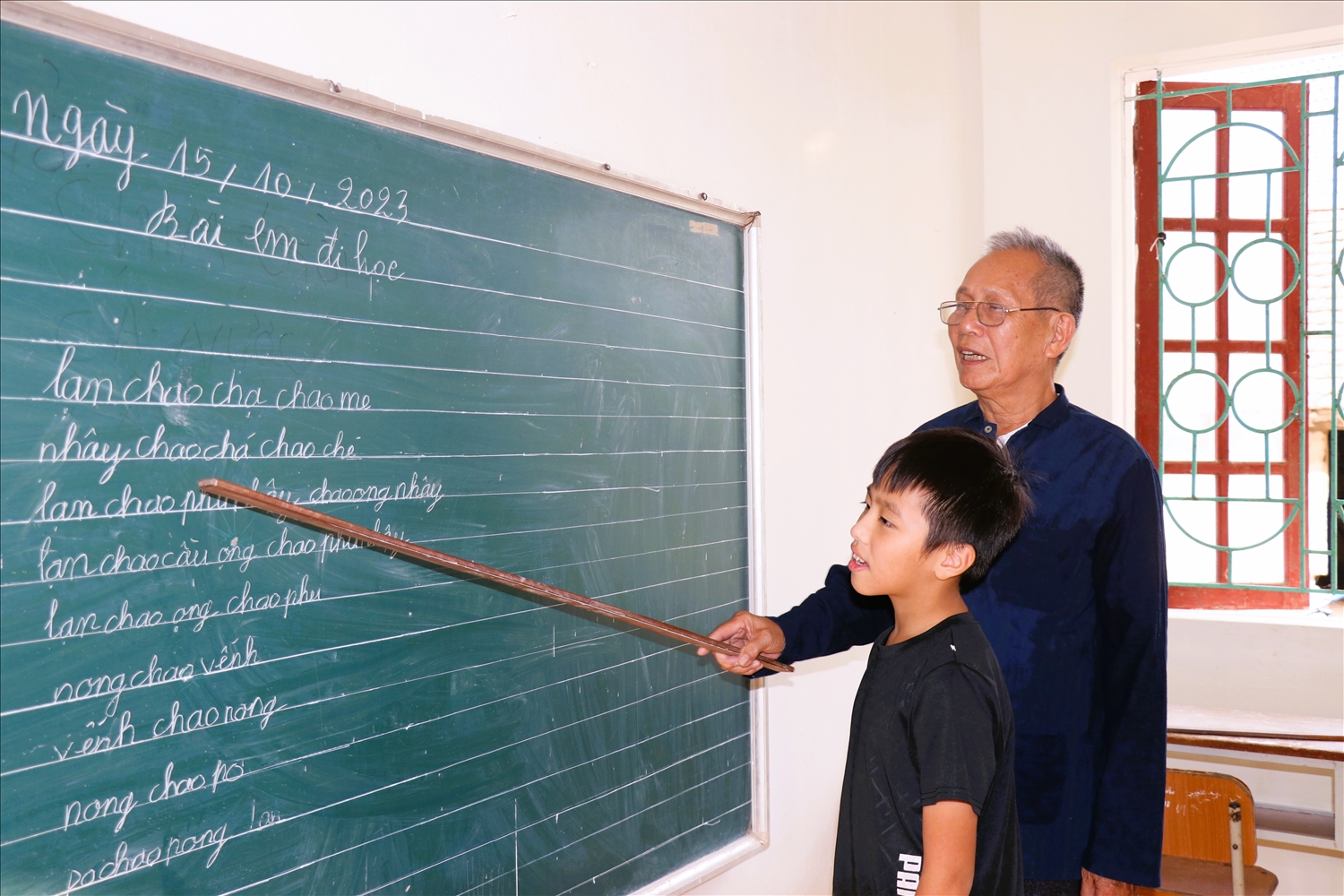 Ông Đàm Xuân Tình dạy tiếng dân tộc cho trẻ em thôn Đồng Bây, xã An Lạc, huyện Sơn Động.