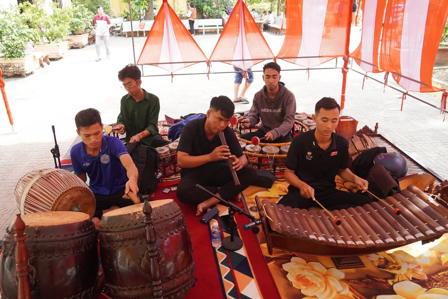  Sinh viên Kim Đạt ( người giữa) hiện đang phụ trách nhóm nhạc ngũ âm biểu diễn tại chùa Âng (TP. Trà Vinh)