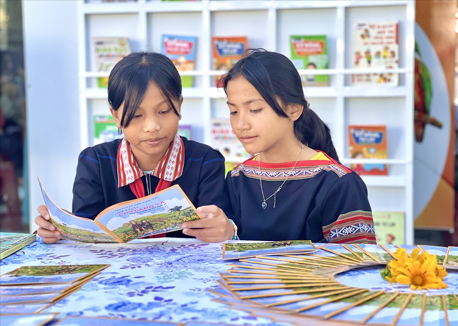Các em học sinh thích thú tìm hiểu, đọc truyện cổ “Sự tích Chư Đang Ya” được biên soạn song ngữ Việt - Gia Rai