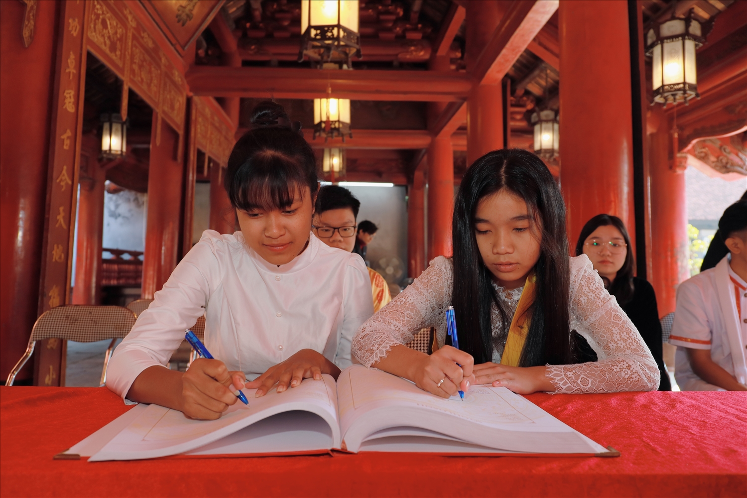 Các em học sinh, sinh viên, thanh niên DTTS ghi sổ Vàng tại Văn Miếu Quốc Tử Giám (Ảnh: Vũ Mừng)