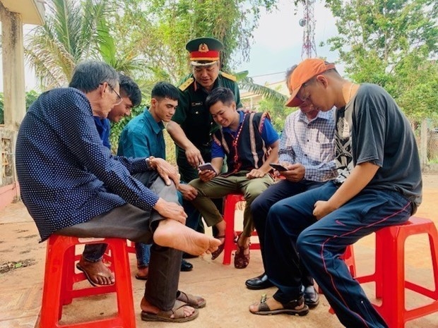 Cán bộ Ban chỉ huy quân sự thị trấn Nhơn Hòa, huyện Chư Pưh (Gia Lai) tuyên truyền hướng dẫn người dân sử dụng mạng xã hội bảo đảm an toàn. Ảnh: Hồng Điệp – TTXVN
