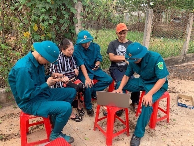 Lực lượng vũ trang thị trấn Nhơn Hòa, huyện Chư Pưh (Gia Lai) hướng dẫn người dân sử dụng mạng xã hội bảo đảm an toàn. Ảnh: Hồng Điệp - TTXVN