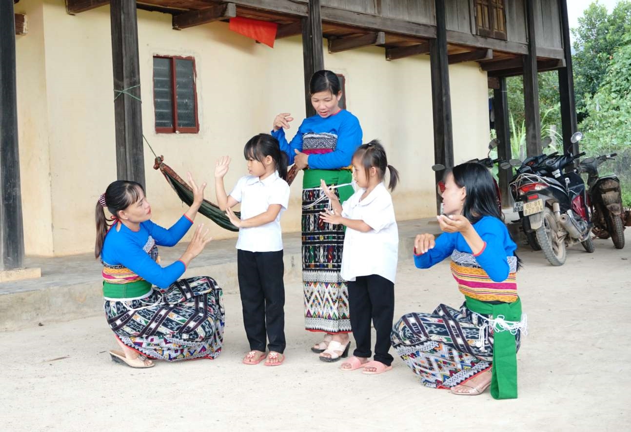Các thành viên trong Đội văn nghệ truyền dạy điệu múa xòe cho con em mình. 