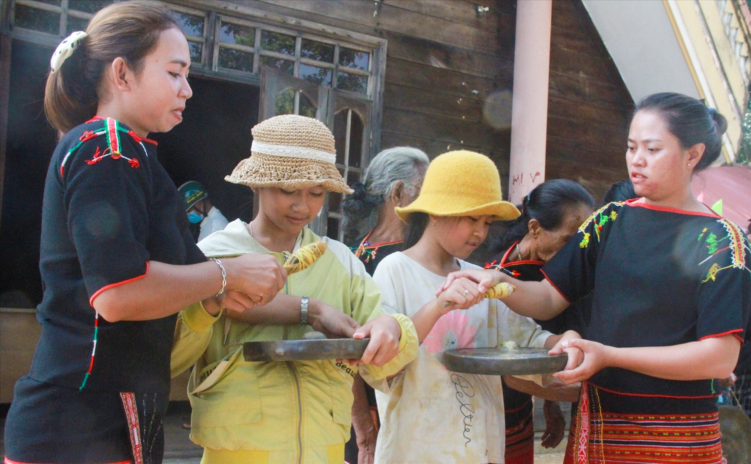 H’Lâm Hmok (bìa phải) truyền dạy đánh chiêng cho các trẻ gái người Ê Đê Bih