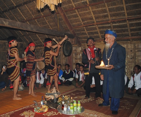 Già làng người Cor và dân làng thực hiện nghi lễ lên nhà mới 