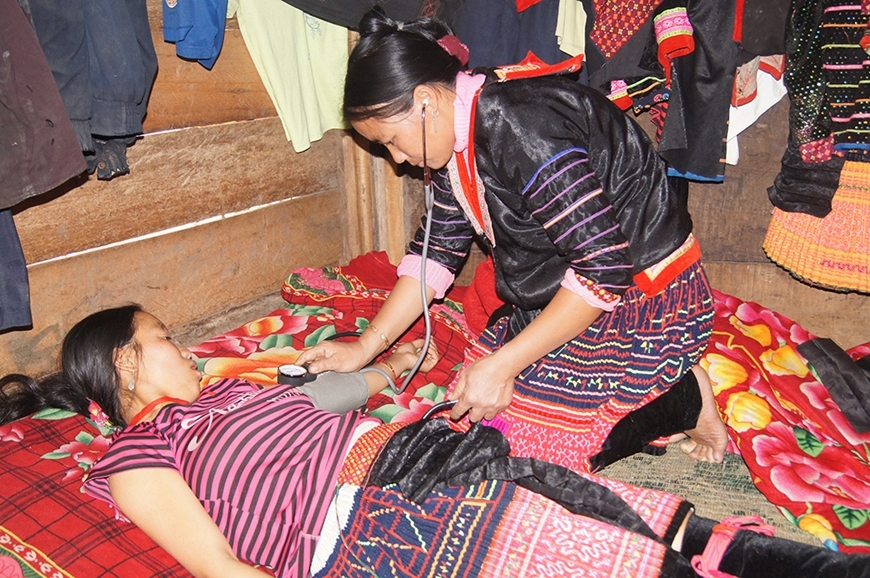 Cô đỡ thôn, bản ở tỉnh Điện Biên thăm khám cho thai phụ. Ảnh do Vụ Sức khỏe Bà mẹ-Trẻ em cung cấp