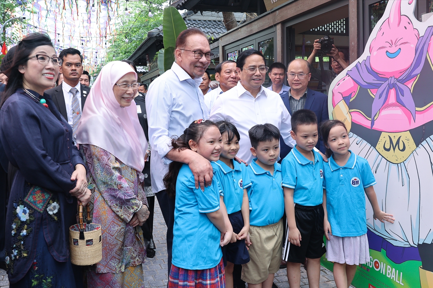 Thủ tướng Phạm Minh Chính và Thủ tướng Anwar Ibrahim cùng hai Phu nhân chụp ảnh lưu niệm cùng các cháu thiếu nhi tại phố sách - Ảnh: VGP/Nhật Bắc