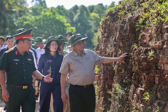 Thủ tướng Phạm Minh Chính bên bức tường thành cổ Quảng Trị ghi lại dấu ấn của những trận đánh vô cùng khốc liệt năm xưa - Ảnh: VGP/Nhật Bắc