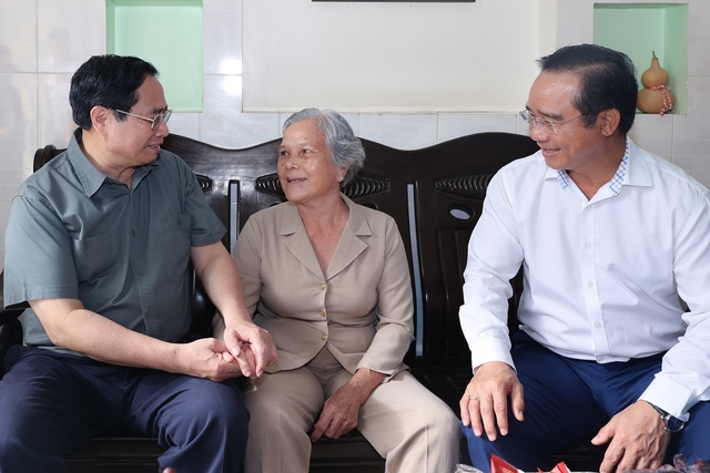 Thủ tướng Phạm Minh Chính ân cần hỏi thăm sức khỏe thương binh Phạm Thị Xinh - Ảnh: VGP/Nhật Bắc