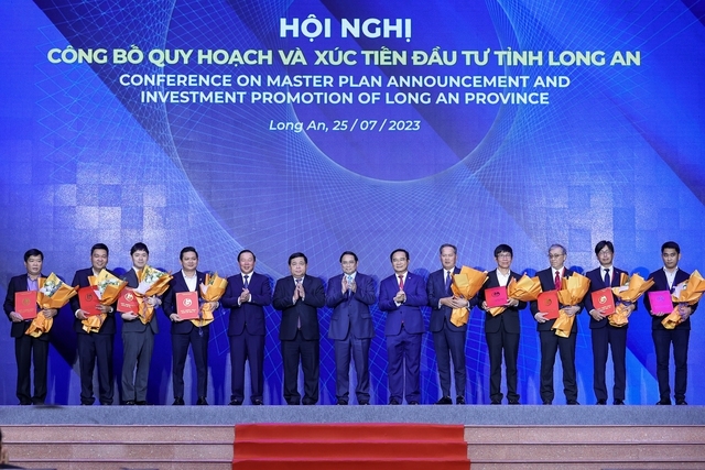 Thủ tướng Phạm Minh Chính, Bộ trưởng Bộ Kế hoạch và Đầu tư Nguyễn Chí Dũng cùng lãnh đạo tỉnh Long An chụp ảnh lưu niệm với các nhà đầu tư được trao Giấy chứng nhận chủ trương đầu tư - Ảnh: VGP/Nhật Bắc