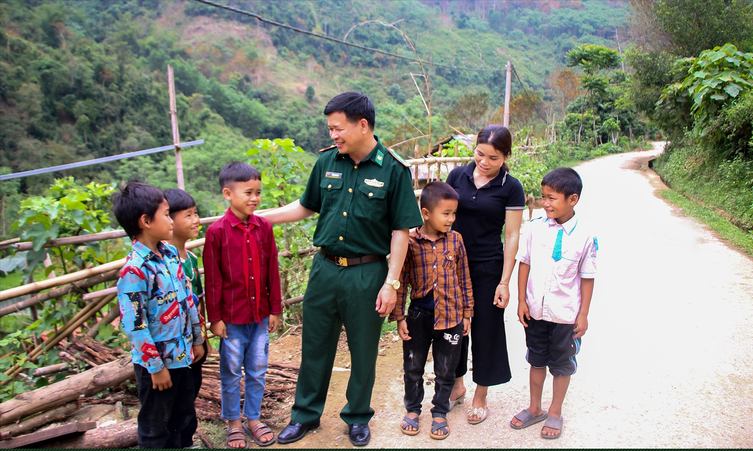 Trung tá Hồ Xuân Tuyến trò chuyện với người dân và các cháu nhỏ ở bản Tùng Hương, xã Tam Quang.