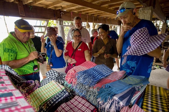 Các sản phẩm từ nghề dệt khăn choàng thu hút du khách quốc tế. Ảnh: NH. 