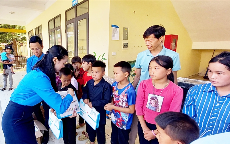 Bí thư Chi đoàn Thanh niên Báo Dân tộc và Phát triển Phạm Thị Thanh Huyền trao quà cho các em học sinh Trường PTDT Bán trú Tiểu học và THCS xã Nàng Đôn
