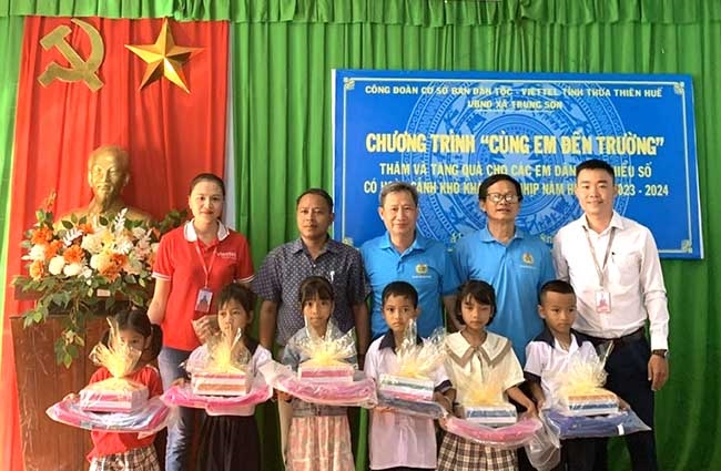 Ông Lê Xuân Hải - Phó Trưởng Ban Dân tộc (người đứng giữa) tặng quà và chụp ảnh lưu niệm với các em học sinh có hoàn cảnh khó khăn