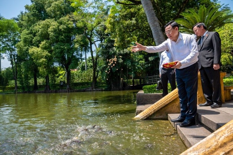 Chủ tịch Quốc hội Vương Đình Huệ cho cá ăn trong ao cá Bác Hồ.
