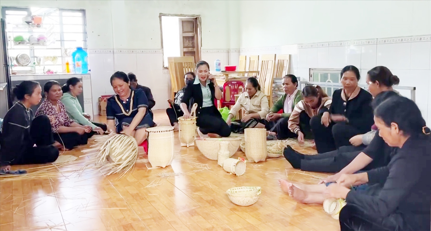 Phó Chủ tịch UBND xã (người nghe điện thoại) cùng tập thể bà con đan lát thôn Duệ.