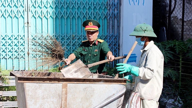 Cán bộ lực lượng vũ trang cùng người lao động thu gom rác tại thị trấn Đồng Mỏ, huyện Chi Lăng