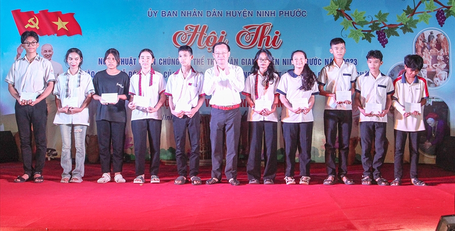 Đồng chí Nguyễn Hữu Tuấn - Bí thư Huyện ủy Ninh Phước trao học bổng Trần Thi cho các em học sinh thị trấn Phước Dân