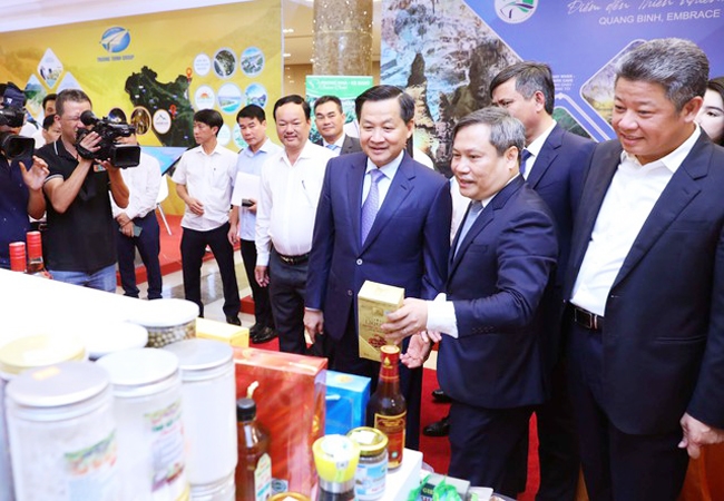 Bí thư Tỉnh ủy Quảng Bình Vũ Đại Thắng giới thiệu với Phó Thủ tướng Lê Minh Khái các sản phẩm chủ lực của tỉnh Quảng Bình. (Ảnh VGP)