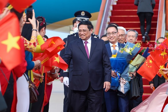 Cán bộ, nhân viên Đại sứ quán Việt Nam và đại diện cộng đồng Việt Nam tại Trung Quốc chào đón Thủ tướng Phạm Minh Chính và đoàn đại biểu Việt Nam - Ảnh: VGP/Nhật Bắc