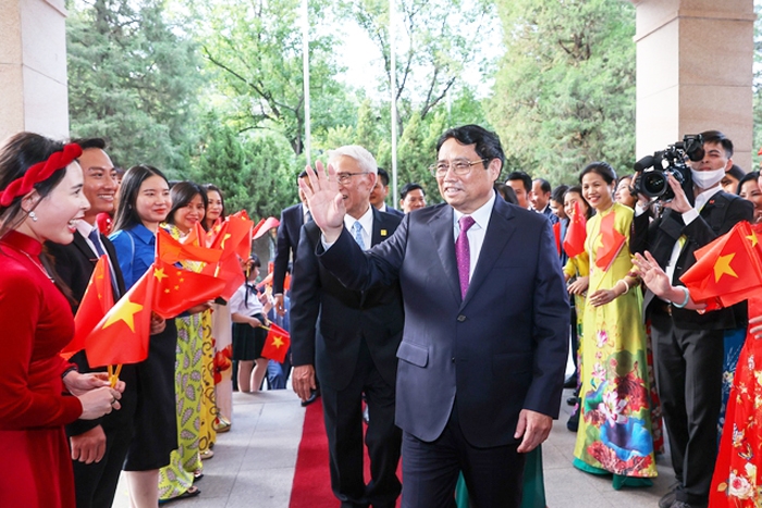 Đại diện kiều bào vui mừng đón Thủ tướng Phạm Minh Chính tới thăm chính thức Trung Quốc và dự Diễn đàn Kinh tế thế giới - Ảnh: VGP/Nhật Bắc
