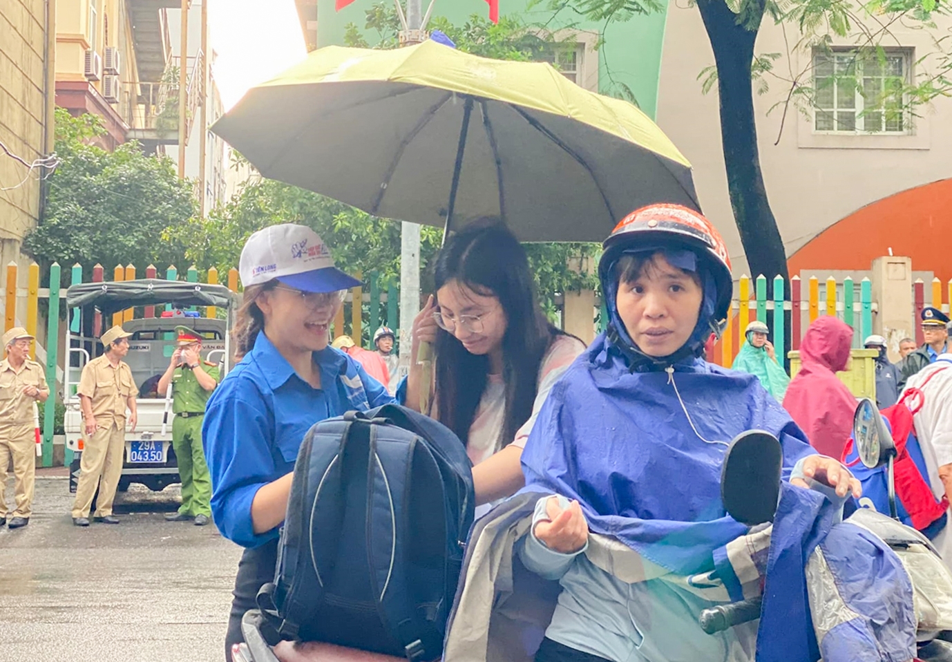 Sẵn sàng ô che, áo mưa để đón thí sinh từ khu vực ngoài cổng trường vào trong khu vực thi