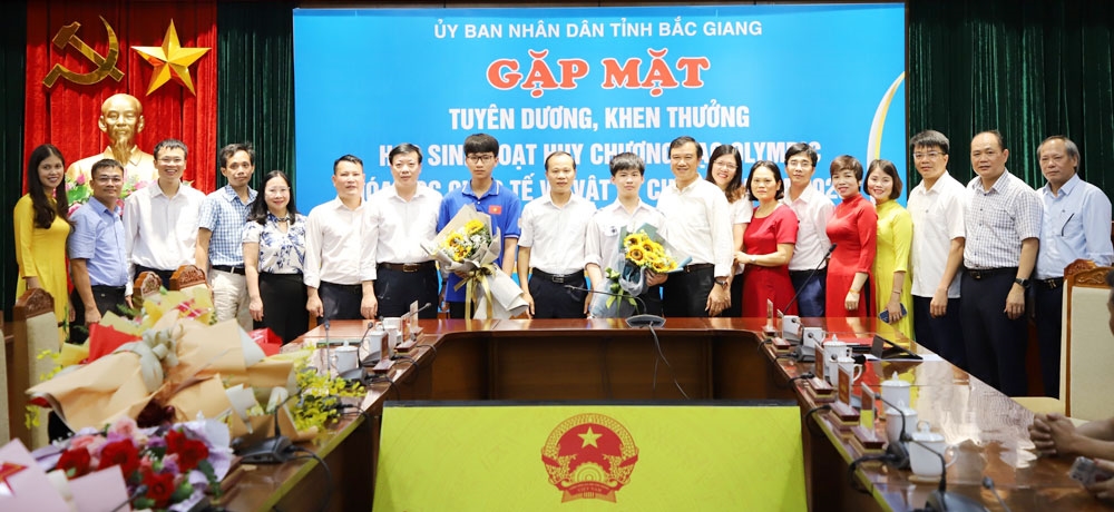 Lãnh đạo UBND tỉnh Bắc Giang cùng các thầy cô chụp ảnh lưu niệm với hai em học sinh đoạt huy chương.