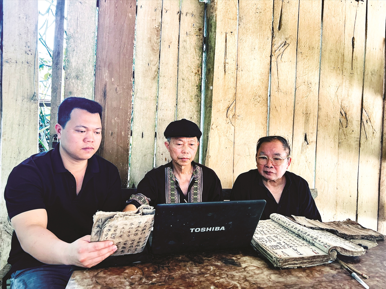 Ông Đặng Văn Xuân (ngồi giữa) thực hiện soạn bài giảng về chữ Nôm Dao trên máy tính.