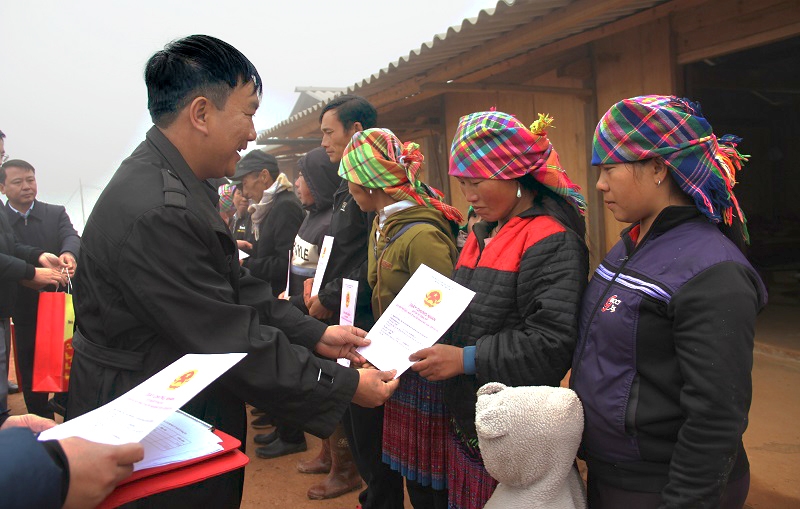 Đồng chí Lê Trọng Khang - Phó Bí thư Huyện ủy, Chủ tịch UBND huyện trao giấy chứng nhận quyền sử dụng đất cho các hộ gia đình ở khu tái định cư. Ảnh: BYB