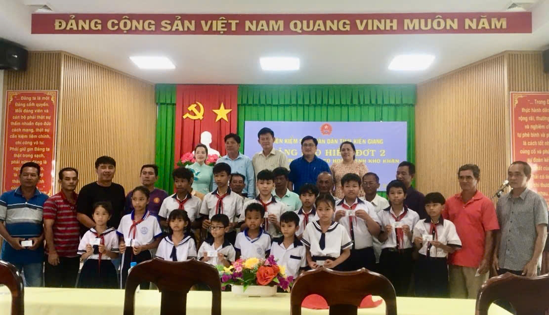 Đại diện lãnh đạo Viện Kiểm sát Nhân dân tỉnh Kiên Giang trao thẻ BHYT đến các cháu học sinh 