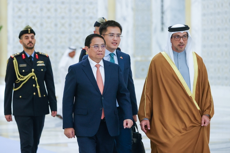 Phó Tổng thống Sheikh Mansour Bin Zayed Al Nahyan đón Thủ tướng Phạm Minh Chính tại nơi đỗ xe và sóng bước vào sảnh chính diễn ra Lễ đón chính thức - Ảnh: VGP/Nhật Bắc