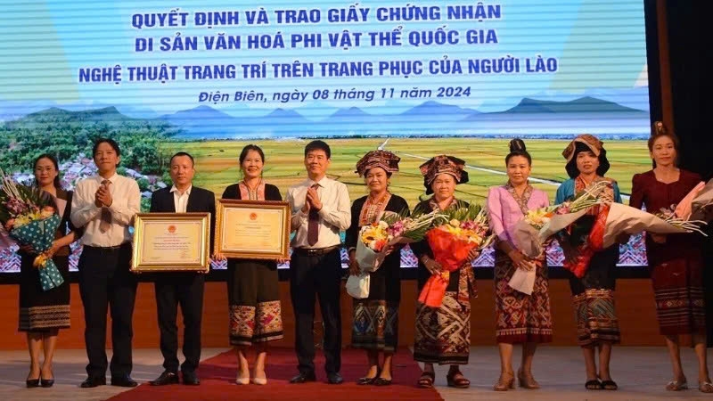 Đồng chí Nguyễn Thái Bình, Chủ tịch Ủy ban nhân dân huyện Điện Biên và đại diện lãnh đạo Sở Văn hóa, Thể thao và Du lịch Điện Biên trao Bằng công nhận Di sản văn hóa phi vật thể quốc gia Nghệ thuật trang trí trên trang phục của người Lào, cho cộng đồng dân tộc Lào ở hai huyện Điện Biên và Điện Biên Đông