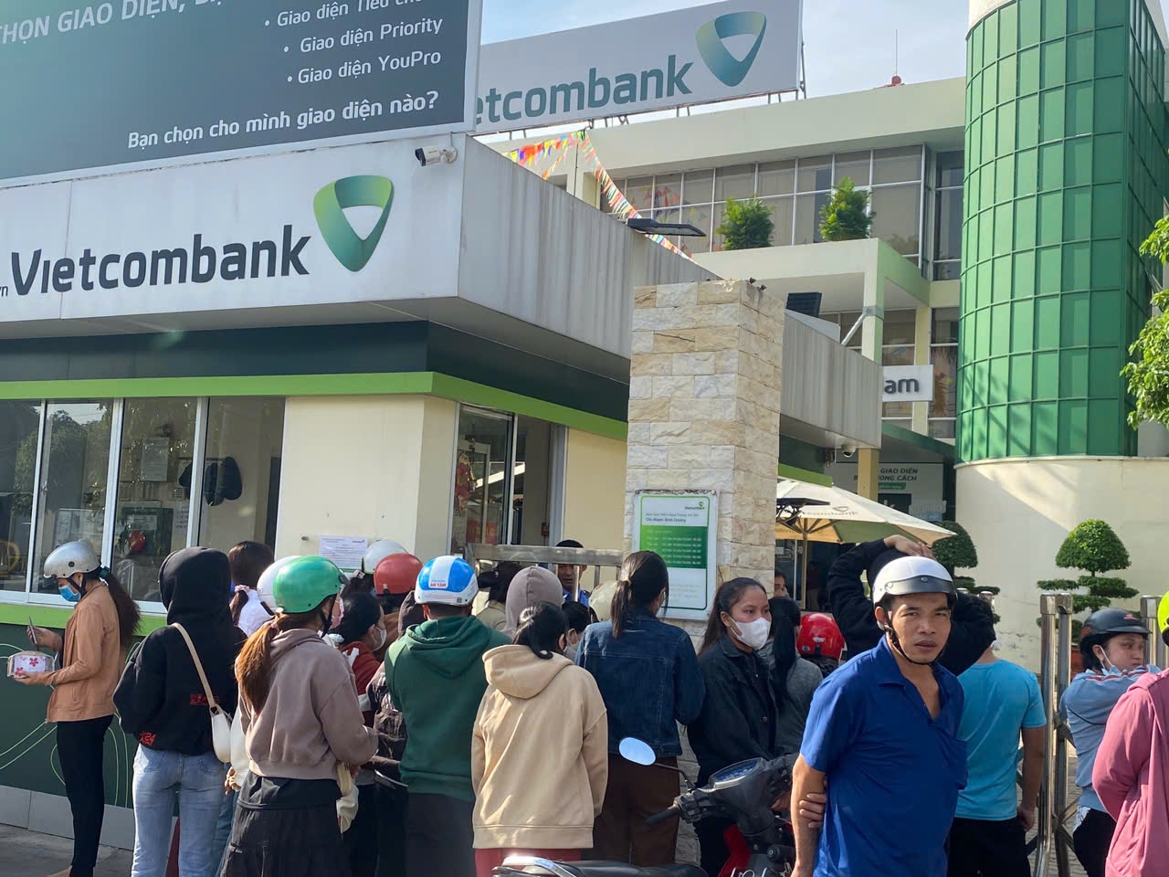 Đám đông công nhân nhốn nháo phía trước Ngân hàng VietcomBank Chi nhánh Bình Dương, đại lộ Bình Dương.