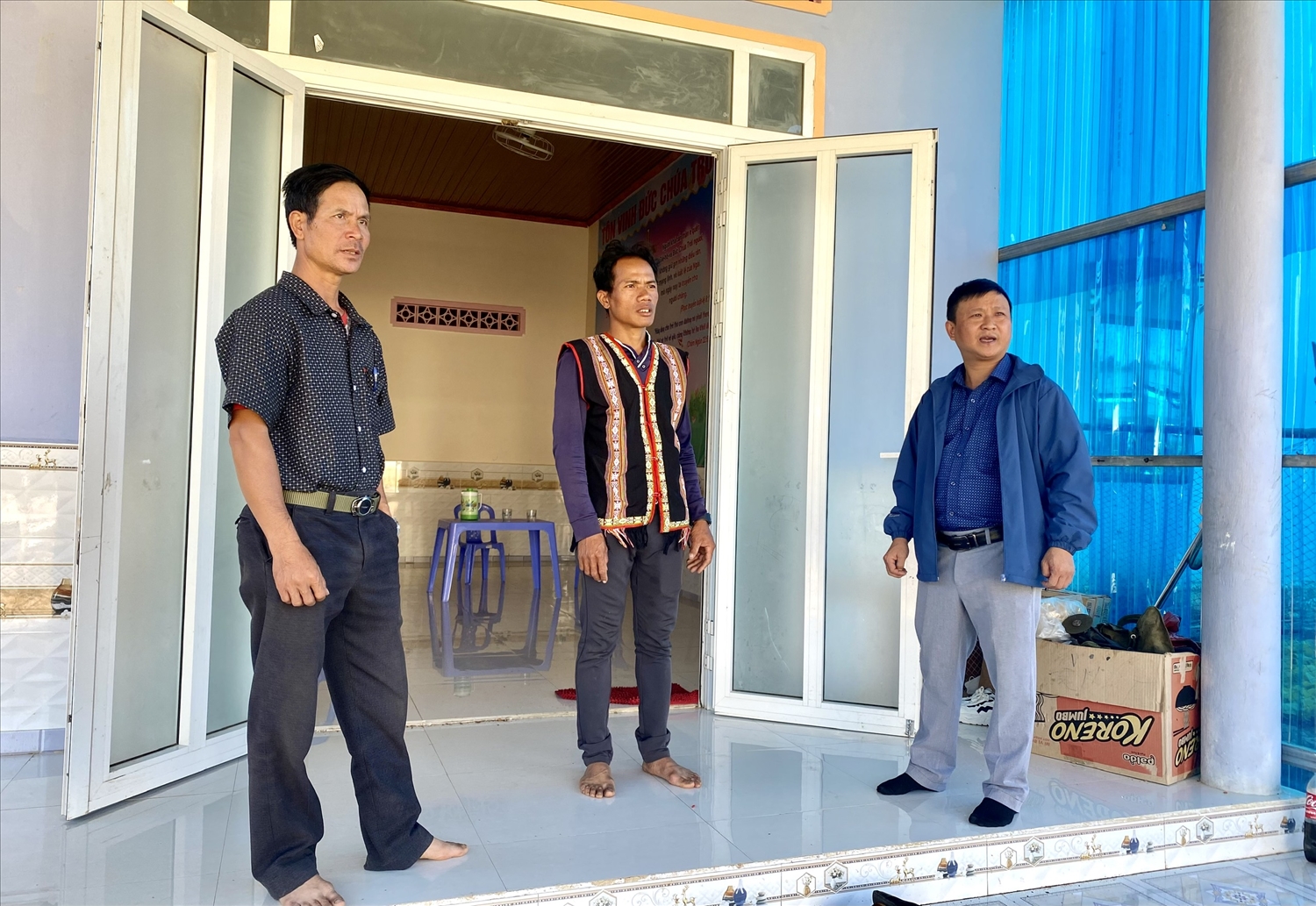 Anh A Thay (đứng giữa) vui mừng bởi gia đình đã ổn định cuộc sống ở khu tái định cư thôn Long Nang