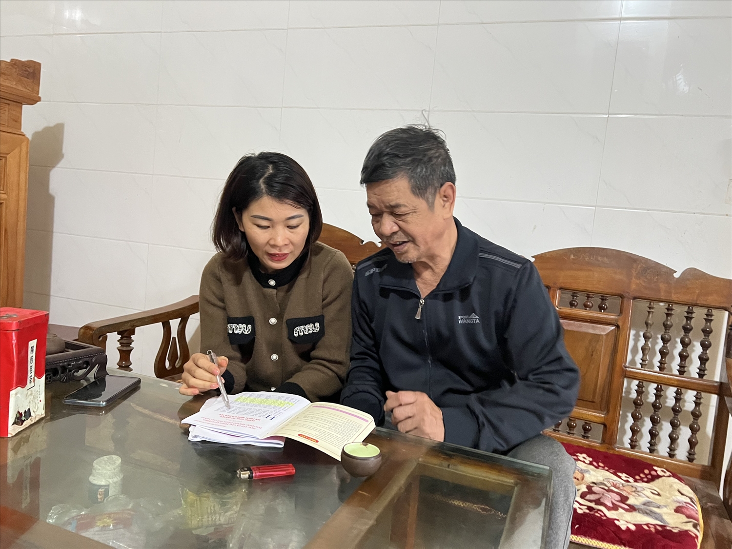 Ông Trần Văn Thiên, thôn Tân Hùng, xã Hùng Đức, huyện Hàm Yên được cán bộ xã hỗ trợ viết đơn xin thoát khỏi hộ nghèo.